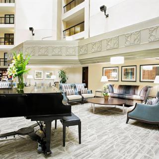 Elegant hotel lobby with grand piano and stylish decor.