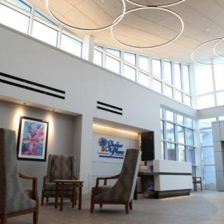 A modern lobby interior with high ceilings, large windows, and contemporary furniture.