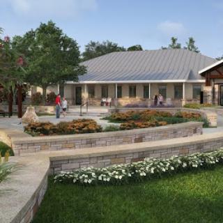 A beautifully designed community building surrounded by gardens and greenery.