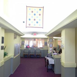 A well-lit office corridor with workspaces on either side and decorative elements.