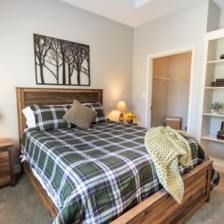 Cozy bedroom with plaid bedding and warm decor.
