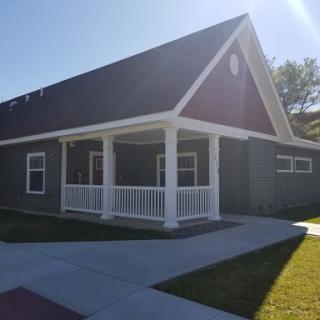A charming residential house with a front porch, basking in bright sunlight.