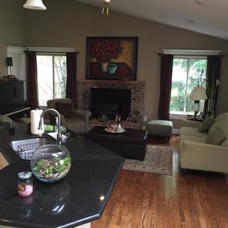 A cozy living room featuring a fireplace, comfortable sofas, and large windows providing natural light.