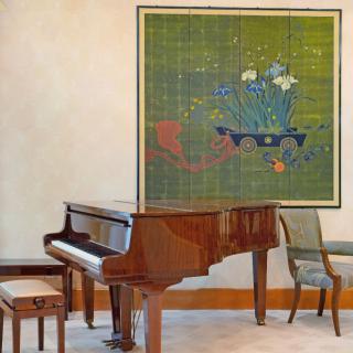A grand piano situated in a room with a vibrant painting on the wall.