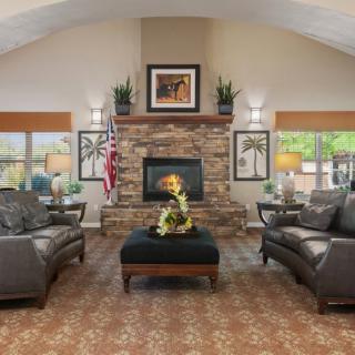 A traditional living room with a stone fireplace, leather sofas, and elegant decor.