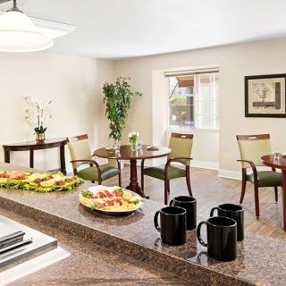 A cozy dining area featuring a breakfast setup with food and mugs on the countertop.