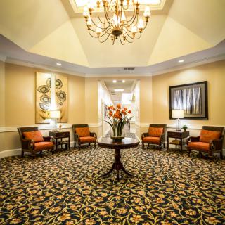 Elegant lobby with a chandelier, comfortable seating, and floral centerpiece.