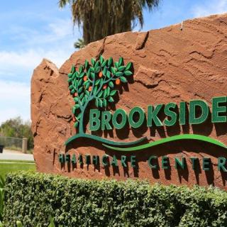 Entrance sign to Brookside Wildlife Center surrounded by greenery.