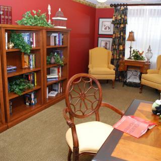 A cozy home library with bookshelves and comfortable reading chairs.