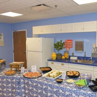 A kitchen setup with a buffet table displaying a variety of food items for an event.