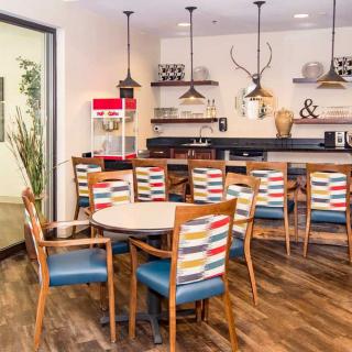 A modern dining area with colorful chairs and decorative elements.