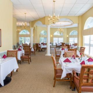 Elegant restaurant dining area with neatly set tables and large windows.