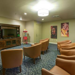 A cozy seating area with a television and decorative posters on the wall.