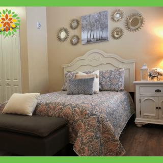 A cozy bedroom with a neatly made bed, decorative pillows, and wall art that creates a serene ambiance.