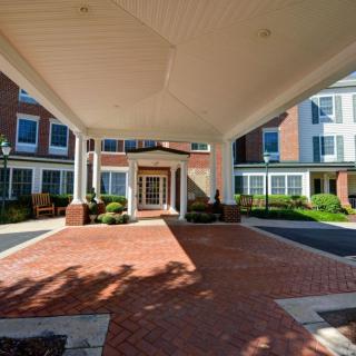 A building entrance with a covered walkway and landscaped surroundings.