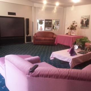 A cozy living room with pink couches and a large television.