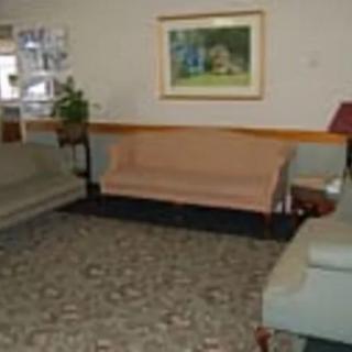 A quiet waiting room with sofas, chairs, and a framed picture on the wall.