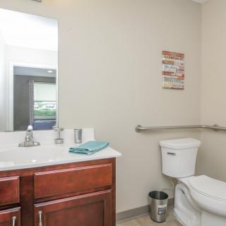 A well-organized bathroom with a sink, mirror, and toilet.
