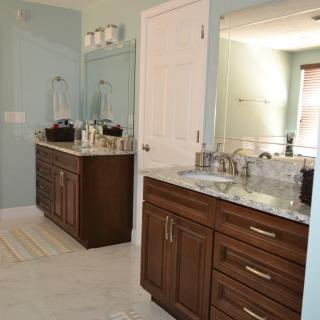 A modern bathroom with double sinks and wooden cabinets.