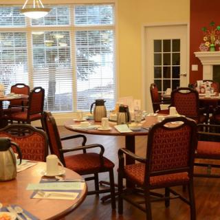 A cozy dining room with neatly arranged tables and chairs, set for a meal.