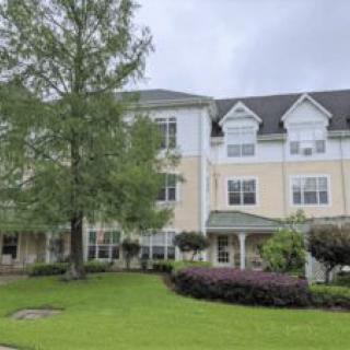 A view of a residential building surrounded by lush landscaping.