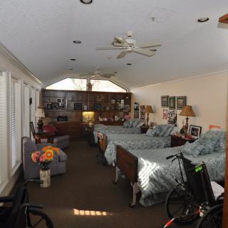A spacious bedroom with multiple beds, cozy decor, and a wheelchair-accessible setup.