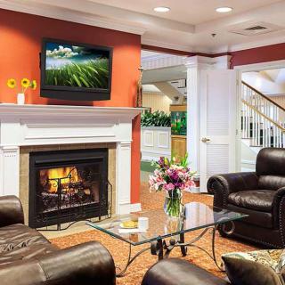 A cozy living room featuring a fireplace, leather seating, and a TV mounted above the mantel.