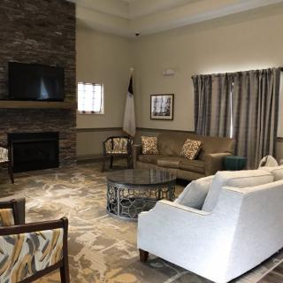 A cozy living room with comfortable seating, featuring a fireplace and television.