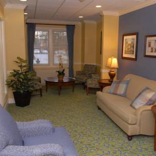 A cozy living room with sofas, chairs, a lamp, and decorative elements.