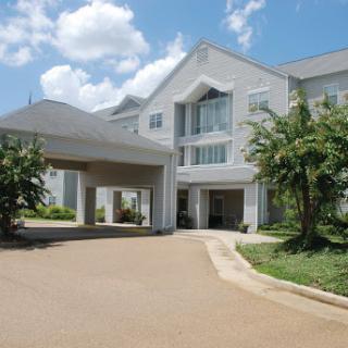 A modern hotel building with an inviting entrance and lush greenery.