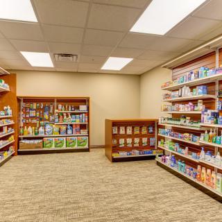 An interior view of a pharmacy with well-organized shelves displaying various products.