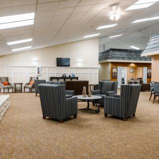 A spacious lobby area with comfortable seating and a television.