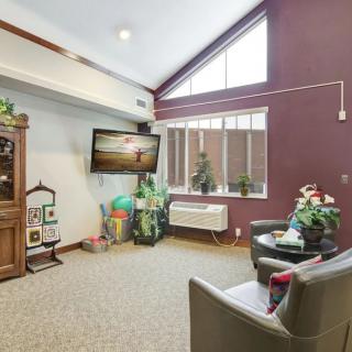 A cozy living room with a television, sofa, and large window.