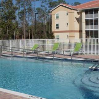 An outdoor swimming pool with lounge chairs and a building in the background.
