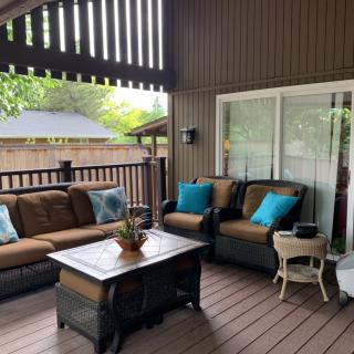 A cozy covered patio with comfortable seating and a coffee table.