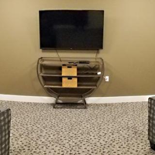 A minimalist living room setup with a mounted television and a small entertainment center.