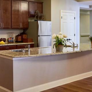 A modern kitchen with wooden cabinets and a granite countertop.