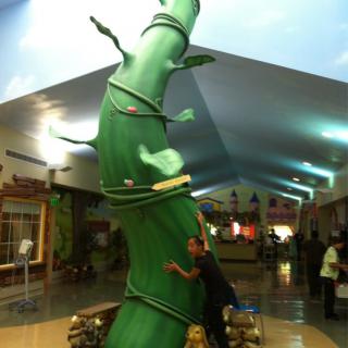 A whimsical beanstalk decoration inside a shopping mall.