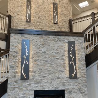A modern interior with a stone fireplace, artwork on the wall, and dual staircases.
