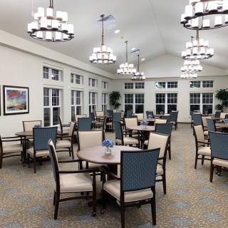 Elegant dining room with multiple tables and chandeliers.