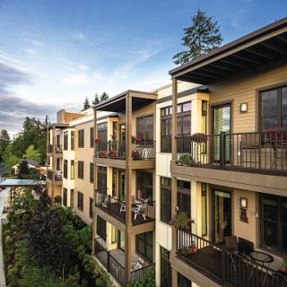 A modern apartment complex featuring spacious balconies and lush landscaping.