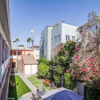 A sunny courtyard surrounded by residential buildings with lush greenery.