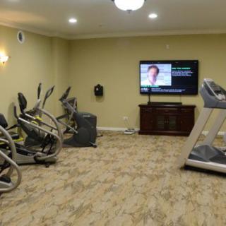 A cozy gym with exercise equipment and a television.