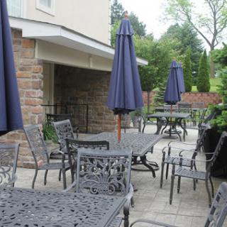 A serene outdoor patio area featuring tables and chairs with umbrellas for shade.