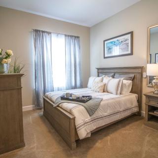 A cozy and well-decorated bedroom with a comfortable bed, soft lighting, and tasteful furnishings.
