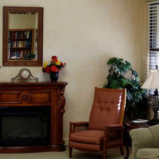 A cozy living room with a comfortable chair, fireplace, and decorative elements.