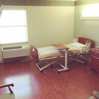 A hospital room equipped with a patient bed and essential medical furnishings.