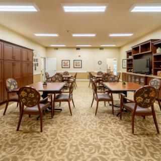 A well-organized conference room with multiple tables and chairs arranged for meetings.