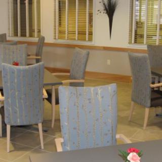 An empty dining room with neatly arranged chairs and tables.