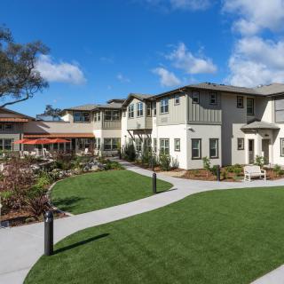 A modern residential building with a well-maintained garden and pathways.